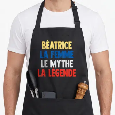 Tablier de cuisine noir avec inscription colorée Béatrice la femme le mythe la légende en lettres capitales.
