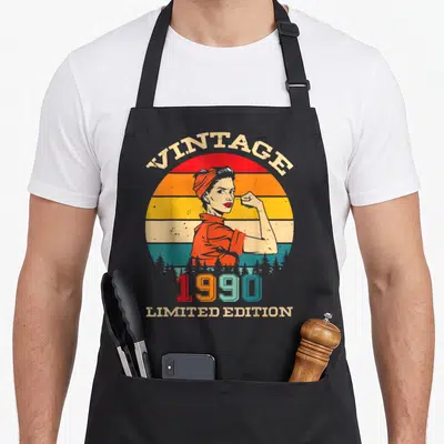 Tablier de cuisine noir avec illustration vintage femme musclée et texte 1990 Limited Edition