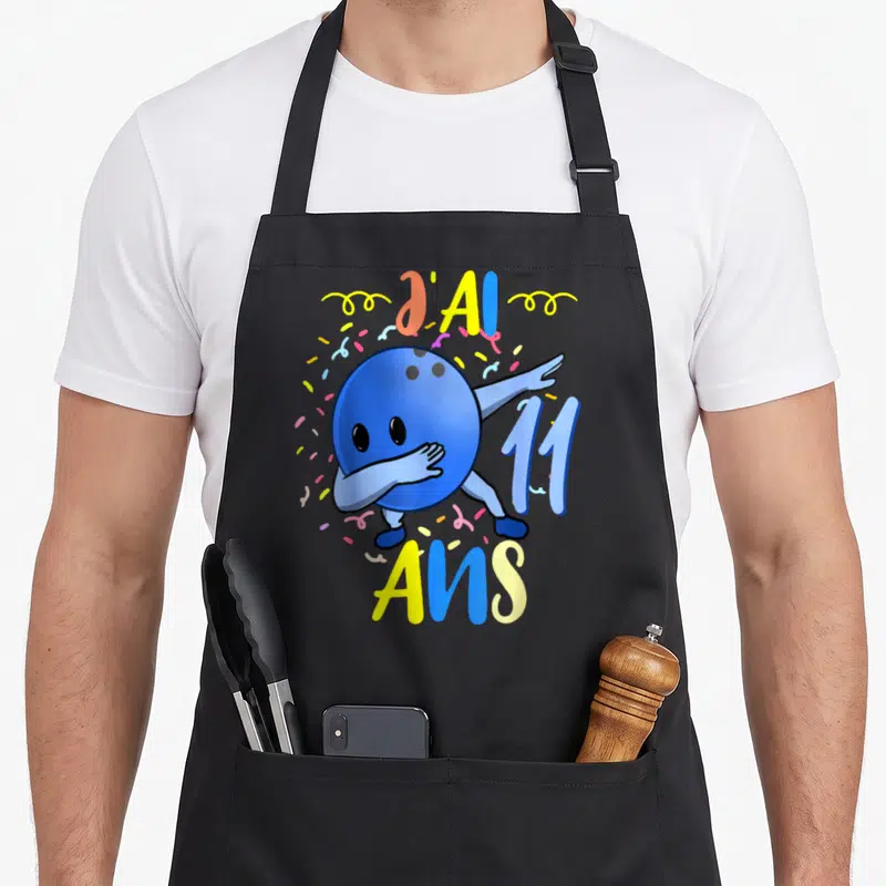 Tablier de cuisine noir avec boule de bowling bleue faisant le dab et texte J'ai 11 Ans entouré de confettis.