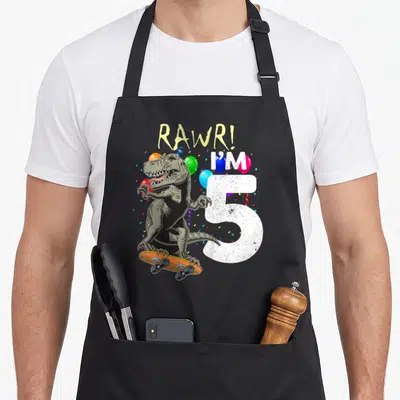 Tablier de cuisine noir avec dinosaure sur skateboard, chiffre 5 et RAWR. en lettres colorées.