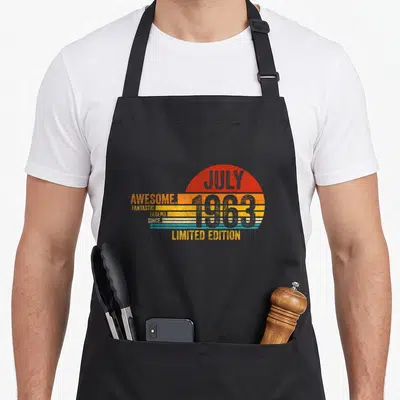 Tablier de cuisine noir avec motif vintage couleur orange et bleu affichant le texte « Génial Depuis Juillet 1963 Édition Limitée ».