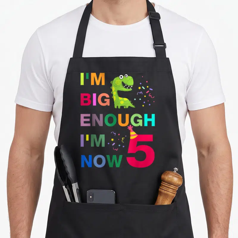 Tablier de cuisine noir avec dinosaure vert et texte multicolore I'M BIG ENOUGH I'M 5 NOW.