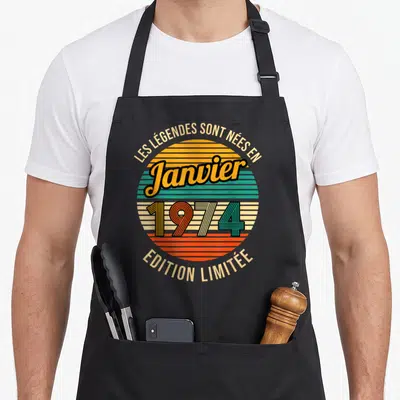 Tablier de cuisine noir avec motif circulaire rétro coloré et texte Les Légendes sont nées en Janvier 1974 « Édition Limitée ».