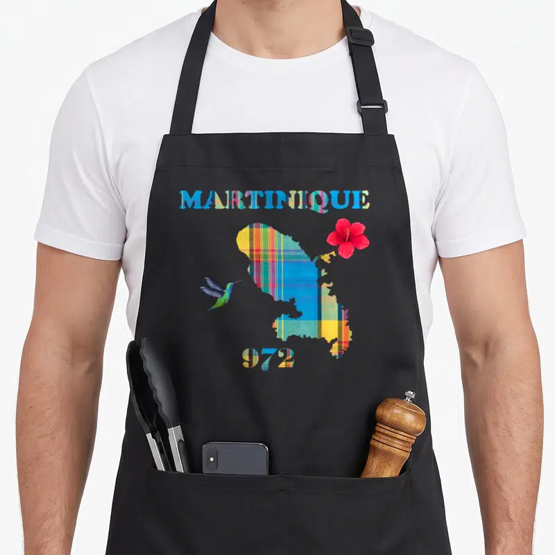 Tablier de cuisine noir avec carte Martinique motif madras, colibri vert et hibiscus rouge vif.
