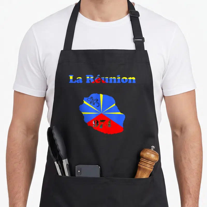 Tablier de cuisine noir avec la carte colorée de La Réunion, le drapeau et le chiffre 974 imprimé en centre.