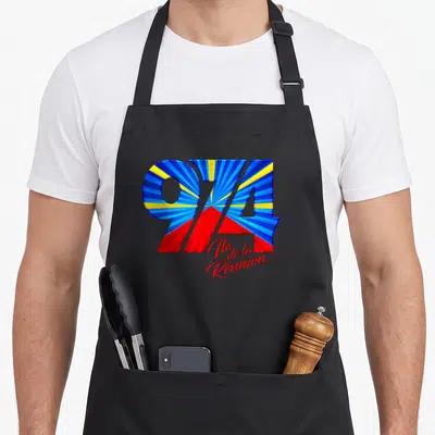 Tablier de cuisine noir avec un 974 coloré aux rayons bleus jaunes et rouges et une signature Ile de la Réunion.