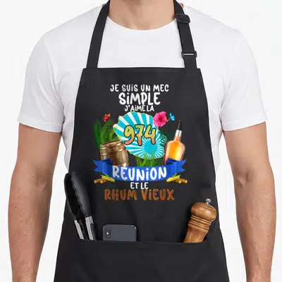 Tablier de cuisine noir avec inscription Je suis un mec simple 974 Réunion et rhum vieux entouré de baril, fleur et palmes.