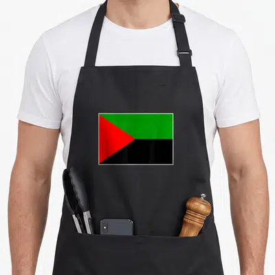Tablier de cuisine noir avec le drapeau de la Martinique aux couleurs vert rouge et noir centré sur le devant.
