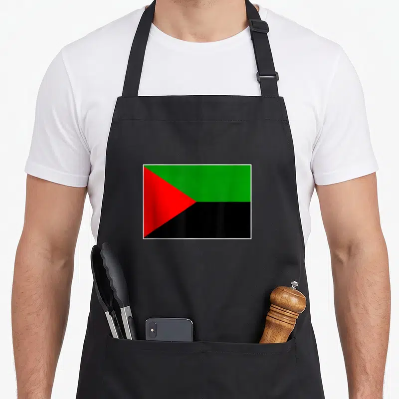 Tablier de cuisine noir avec le drapeau de la Martinique aux couleurs vert rouge et noir centré sur le devant.