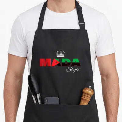 Tablier de cuisine noir avec logo Mada Style aux couleurs rouge vert noir et une couronne blanche au centre.