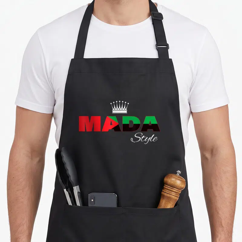 Tablier de cuisine noir avec logo Mada Style aux couleurs rouge vert noir et une couronne blanche au centre.