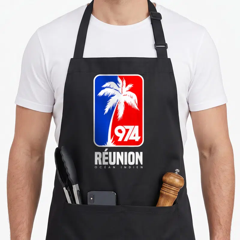 Tablier de cuisine noir avec un logo rectangulaire bleu et rouge affichant un palmier blanc, le chiffre 974 et le texte Réunion Océan Indien.