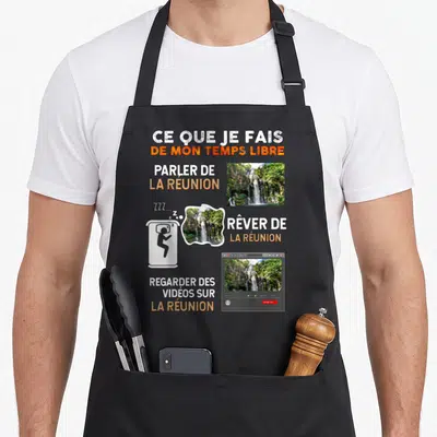 Tablier de cuisine noir avec texte humoristique et photos de cascades de la Réunion illustrant les loisirs du temps libre.