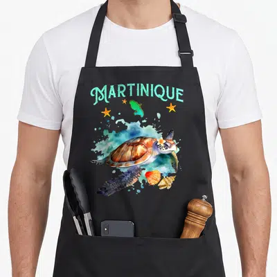 Tablier de cuisine noir avec illustration d'une tortue marine, de coquillages et du mot Martinique en turquoise.