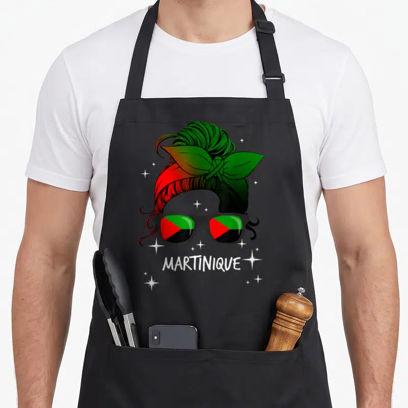 Tablier de cuisine noir avec illustration femme coiffée bandana tricolore lunettes soleil reflets drapeau Martinique texte blanc étoiles scintillantes