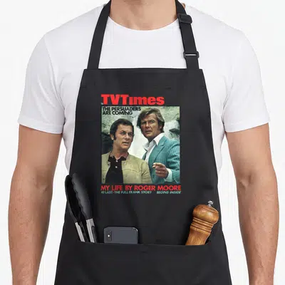 Tablier de cuisine noir avec reproduction de la couverture TV Times 1971 montrant Tony Curtis et Roger Moore.