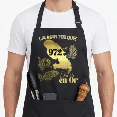 Tablier de cuisine noir avec une carte dorée de La Martinique, le chiffre 972 et des motifs floraux.