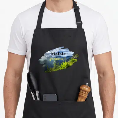 Tablier de cuisine noir avec illustration du cirque de Mafate et le texte Mafate j'ai survécu. en jaune et noir.