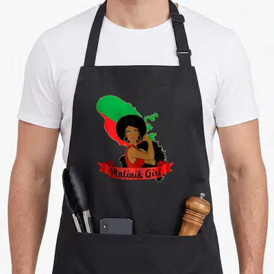 Tablier de cuisine noir avec une femme afro au poing levé devant la carte de la Martinique aux couleurs du drapeau.