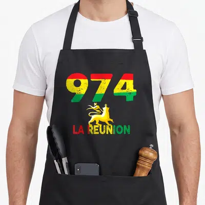 Tablier de cuisine noir avec le chiffre 974 tricolore et le Lion de Judah doré sur fond uni.