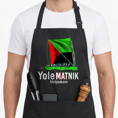 Tablier de cuisine noir avec illustration d'une yole au drapeau tricolore et texte Yole Matnik Matjoukann.