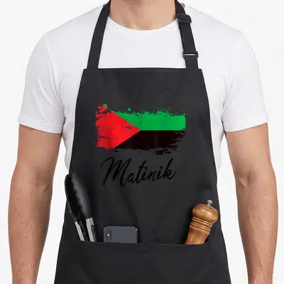Tablier de cuisine noir avec drapeau Martinique style éclaboussure et inscription Matinik en écriture cursive.