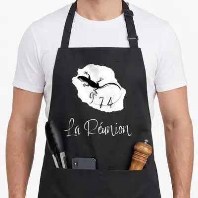 Tablier de cuisine noir avec carte blanche de La Réunion, un gécko noir et le numéro 974 stylisé.