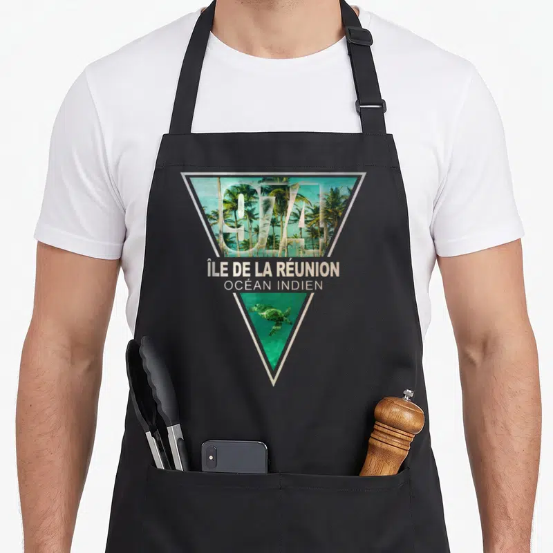 Tablier de cuisine noir avec motif géométrique représentant les palmiers et la tortue de l'île de la Réunion.