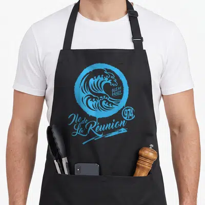 Tablier de cuisine noir avec une grande vague bleue stylisée et le texte Ile de La Réunion 974 imprimé en gras.