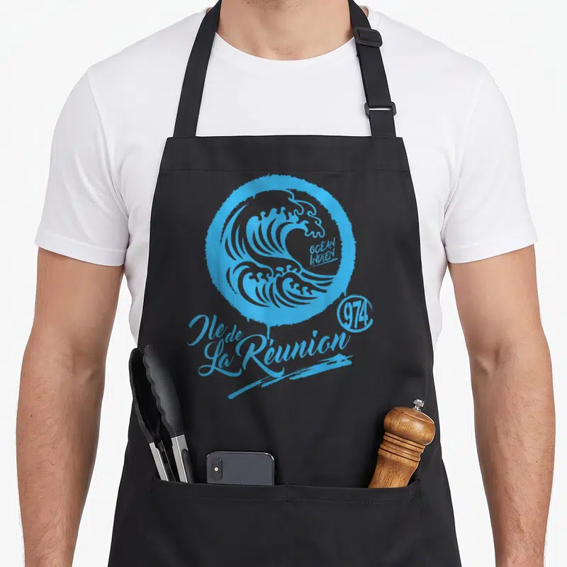 Tablier de cuisine noir avec une grande vague bleue stylisée et le texte Ile de La Réunion 974 imprimé en gras.