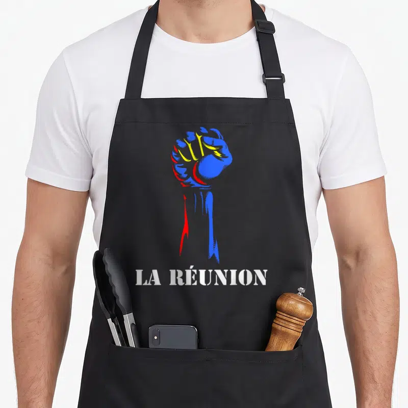 Tablier de cuisine noir avec un poing levé aux couleurs du drapeau de La Réunion et le texte La Réunion en blanc.