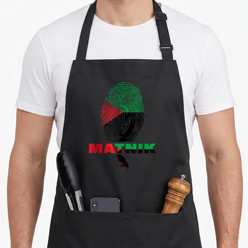 Tablier de cuisine noir avec une grande empreinte digitale tricolore et le mot Matnik en dessous, surmontant une silhouette d'île noire.