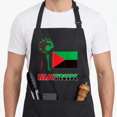 Tablier de cuisine noir avec poing levé vert et rouge, drapeau triangulaire et inscription Matnik colorée.
