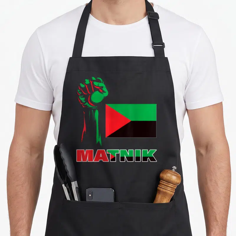 Tablier de cuisine noir avec poing levé vert et rouge, drapeau triangulaire et inscription Matnik colorée.
