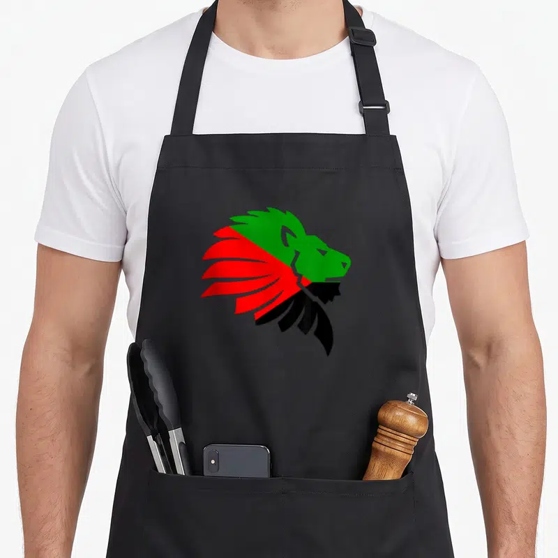 Tablier de cuisine noir avec un lion stylisé aux couleurs vert rouge et noir représentant la Martinique
