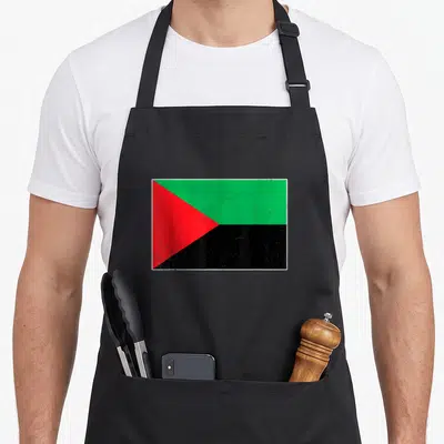 Tablier de cuisine noir avec le drapeau de la Martinique aux couleurs vert rouge et noir en centre.