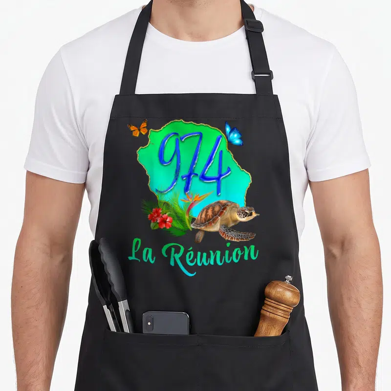 Tablier de cuisine noir avec carte verte 974, tortue de mer, hibiscus rouge et papillons bleus et oranges.