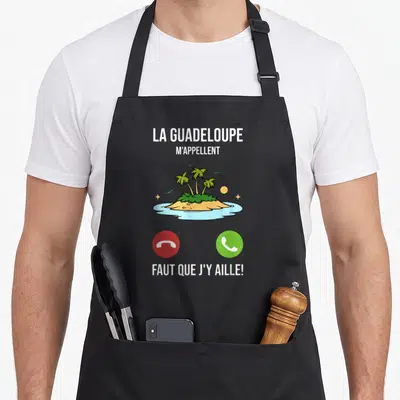 Tablier de cuisine noir avec une île tropicale, palmiers et boutons téléphone rouge et vert imprimés au centre.