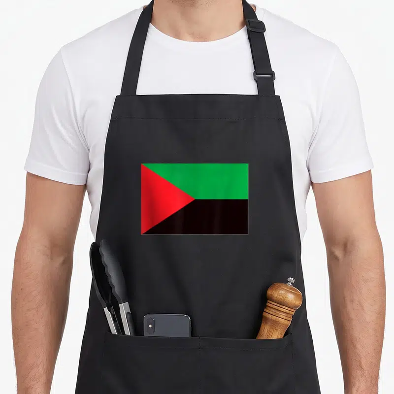 Tablier de cuisine noir avec l'impression du drapeau Martinique aux couleurs vives rouge vert et noir.