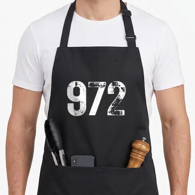 Tablier de cuisine noir avec le code régional 972 Dallas Texas en grandes lettres blanches texturées.