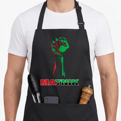 Tablier de cuisine noir avec un poing levé vert et rouge et le mot Matnik en bas.