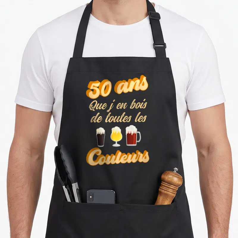 Tablier de cuisine noir avec l'inscription 50 ans que j'en bois de toutes les couleurs au-dessus de trois verres de bière.