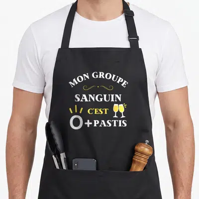 Tablier de cuisine noir avec inscription Mon groupe sanguin c'est O+ Pastis et illustration de deux verres de pastis s'entrechoquant.