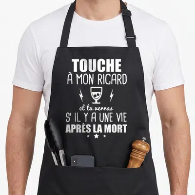 Tablier de cuisine noir avec texte blanc humoristique sur le Ricard et un verre stylisé entre deux éclairs.