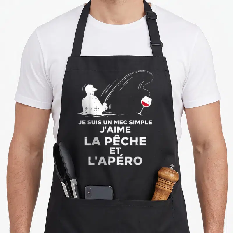Tablier de cuisine noir avec silhouette blanche de pêcheur et verre de vin rouge au-dessus du texte humoristique.