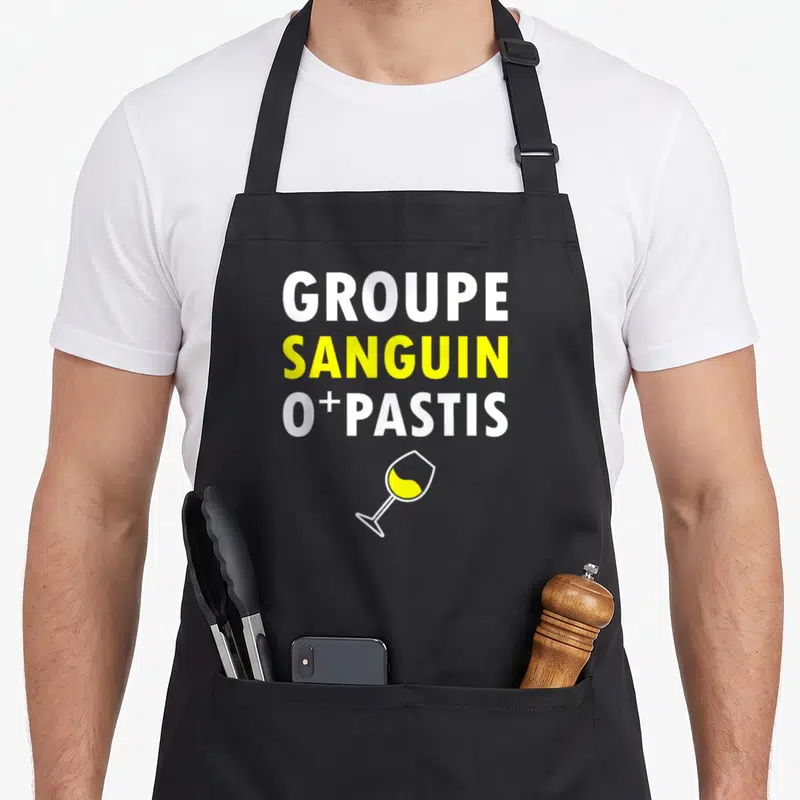 Tablier de cuisine noir avec l'inscription groupe sanguin o plus pastis et un verre jaune.