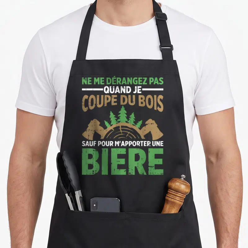 Tablier de cuisine noir avec inscription Ne me dérangez pas quand je coupe du bois sauf pour m'apporter une bière illustré d'un tronc d'arbre.