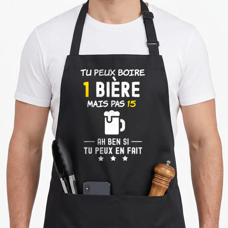 Tablier de cuisine noir avec inscription blanche et jaune sur l'apéro et une illustration de mug de bière.