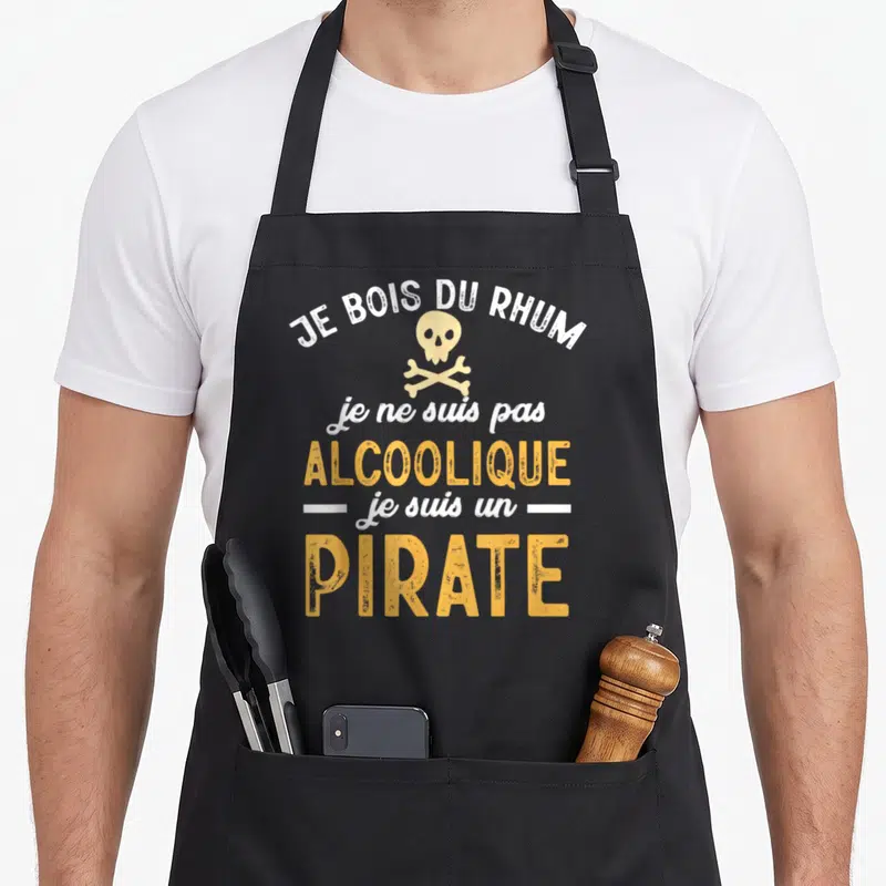 Tablier de cuisine noir avec le texte Je bois du rhum je suis un pirate et un crâne de mort orange.