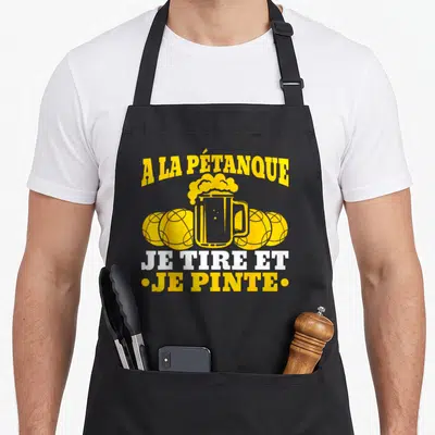Tablier de cuisine noir avec illustration jaune d'un bocal de bière entouré de trois boules de pétanque et texte blanc et jaune.